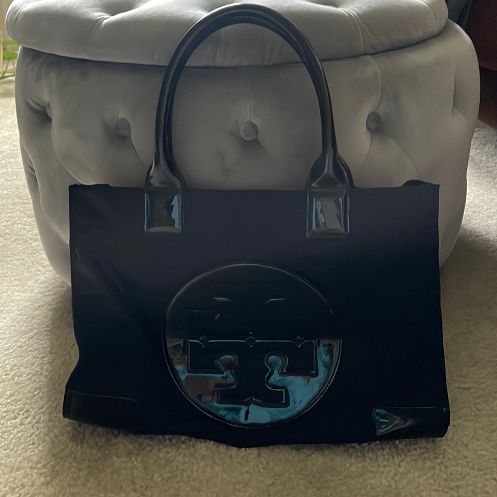Gentle used travel tote with inside pockets and side snaps to close in items.